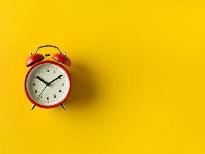 Retro alarm clock on yellow color background